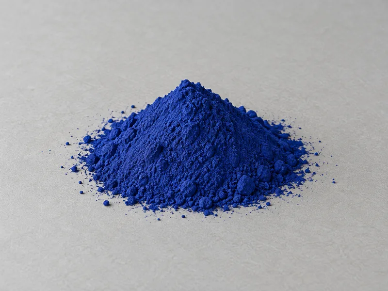 Pigmento azul intenso en polvo, en un montículo sobre una superficie gris